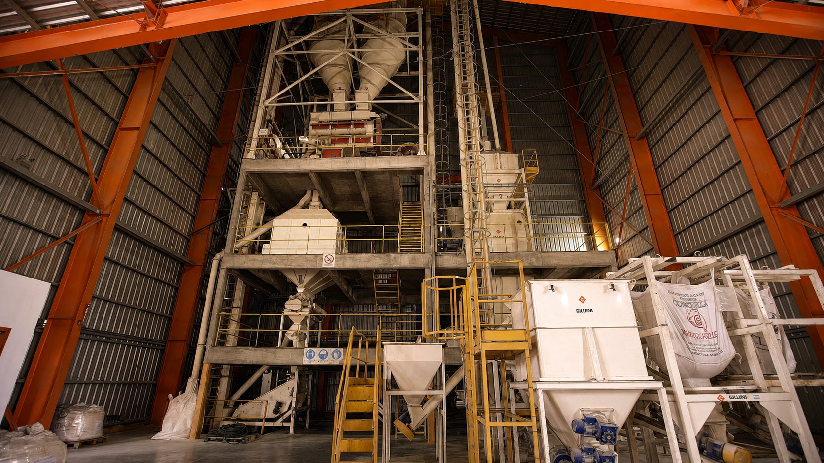 Nave de una planta de alimento balanceado con la torre de proceso, tolvas de descarga y estaciones de bolsones