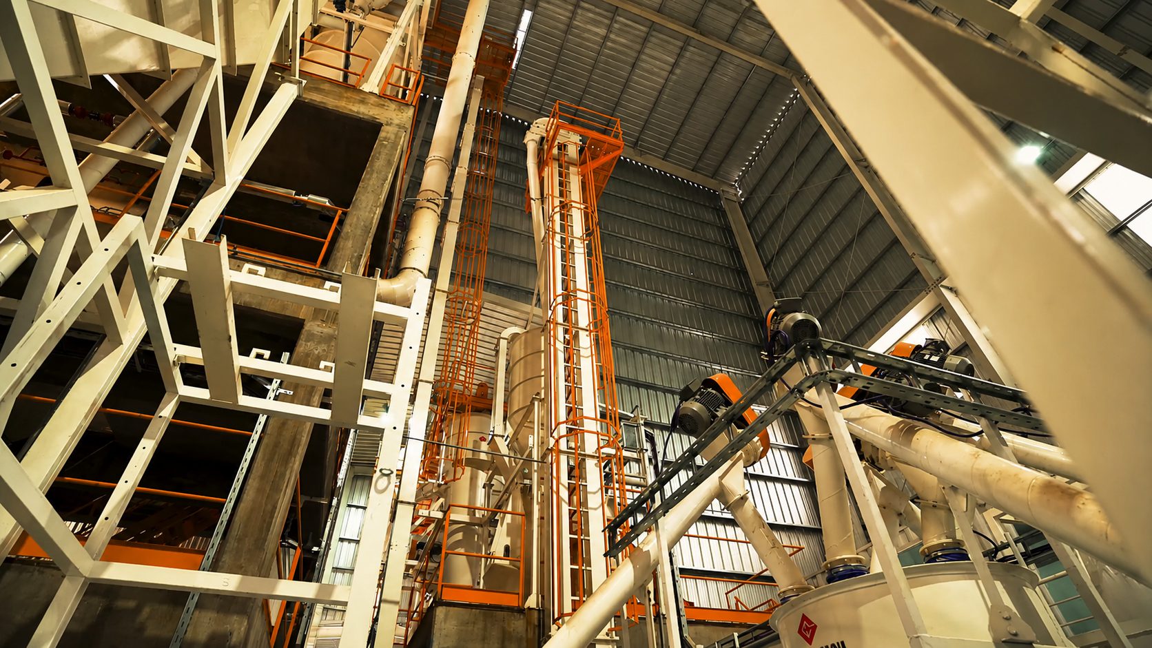 Elevador, transportes y estructura metálica de una línea de proceso dentro de la nave
